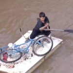 Menino improvisa e transforma porta em canoa para resgatar bicicleta em meio às enchentes no Rio Grande do Sul